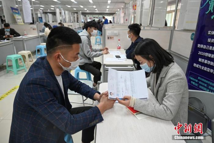 4月14日，招聘者在查看求職者簡歷。<a target='_blank'  data-cke-saved- >中新社</a>記者 王剛 攝