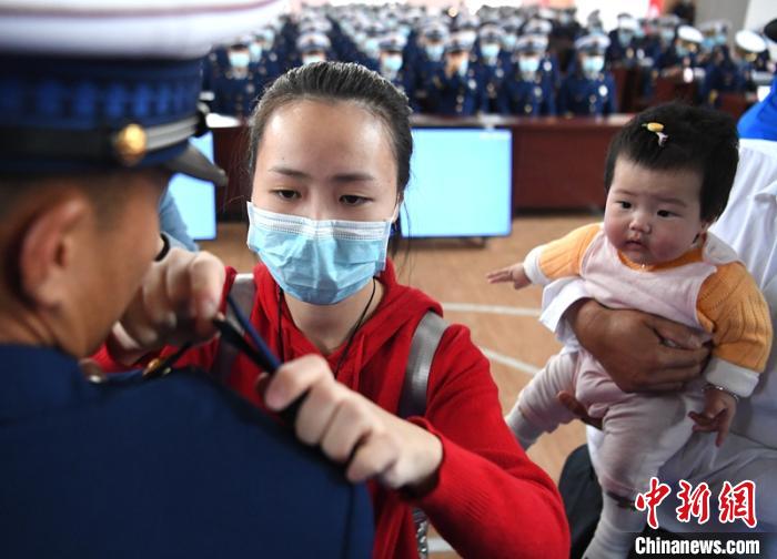 新消防員楊振的妻子彭莉與女兒現(xiàn)場(chǎng)見證丈夫加入“火焰藍(lán)”的神圣時(shí)刻?！⒅铱?攝