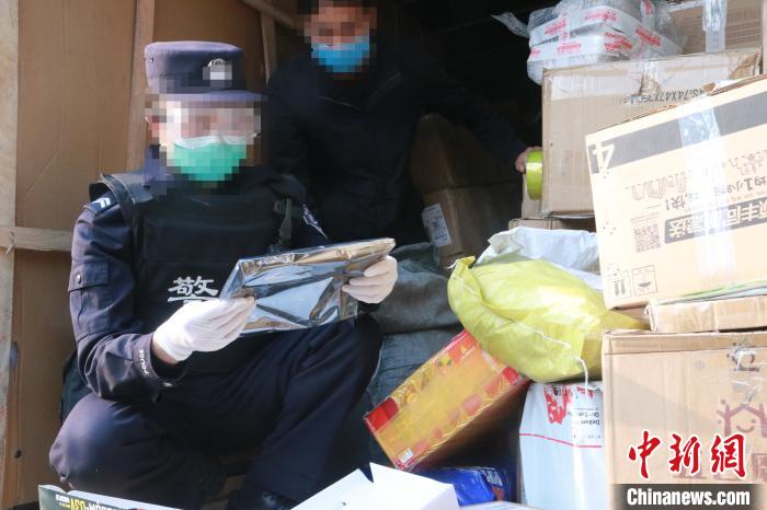 圖為勐康邊檢站民警在對(duì)快遞運(yùn)輸車輛進(jìn)行例行檢查?！钐?攝