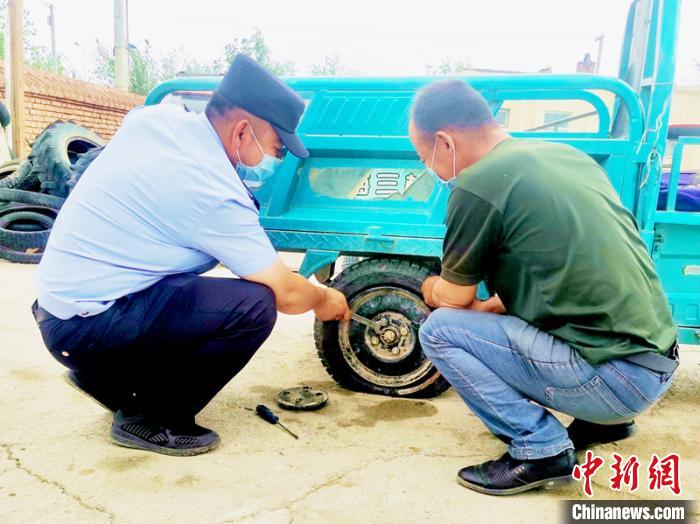賽旦與民警共同維修三輪摩托車?！∫懒窘?攝