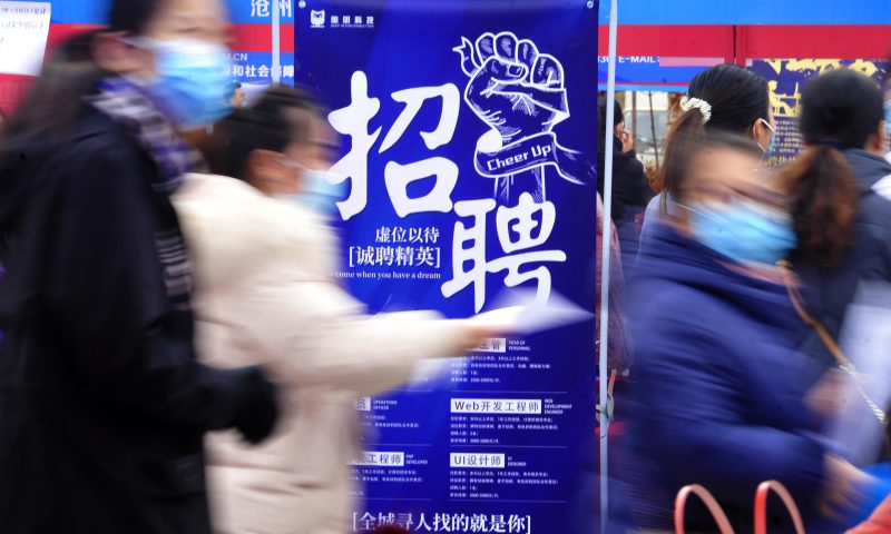 求職者從一家招聘企業(yè)的廣告牌前走過。新華社發(fā)（苑立偉 攝）