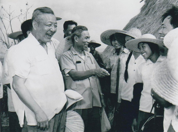 1980年8月底至9月初，習(xí)仲勛（左一）在廣東湛江農(nóng)村視察時(shí)與青年親切交談。