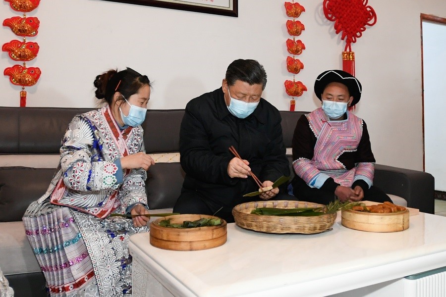 2021年2月3日下午，習(xí)近平在貴州畢節(jié)市黔西縣新仁苗族鄉(xiāng)化屋村苗族村民趙玉學(xué)家，同一家人邊聊家常邊制作當(dāng)?shù)貍鹘y(tǒng)節(jié)日食品黃粑。新華社記者 李學(xué)仁 攝